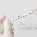 une personne en gants blancs tenant un tube