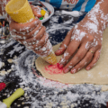 une personne pétrit de la pâte sur une table